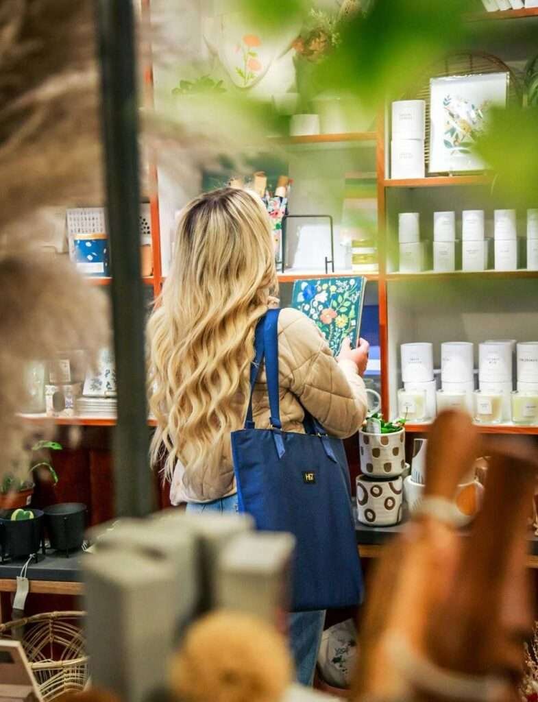 a girl is looking at non toxic skincare products at green beauty store